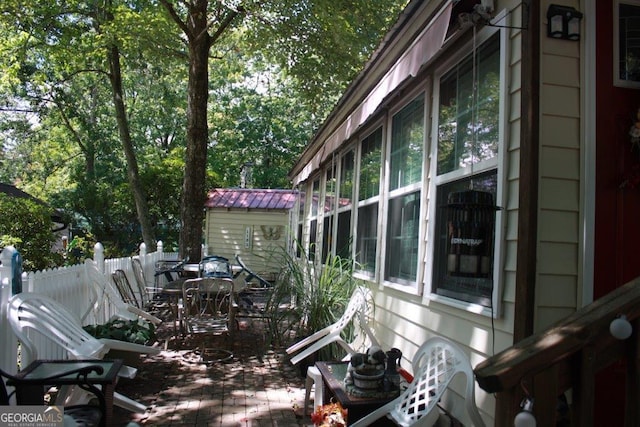 view of home's exterior with a patio and a storage unit