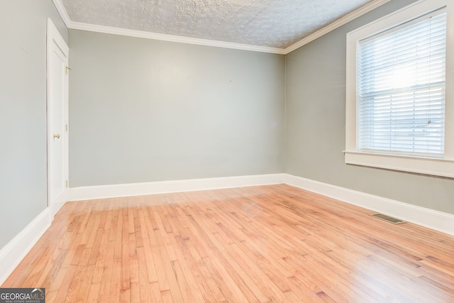 unfurnished room with light hardwood / wood-style floors, a textured ceiling, and ornamental molding