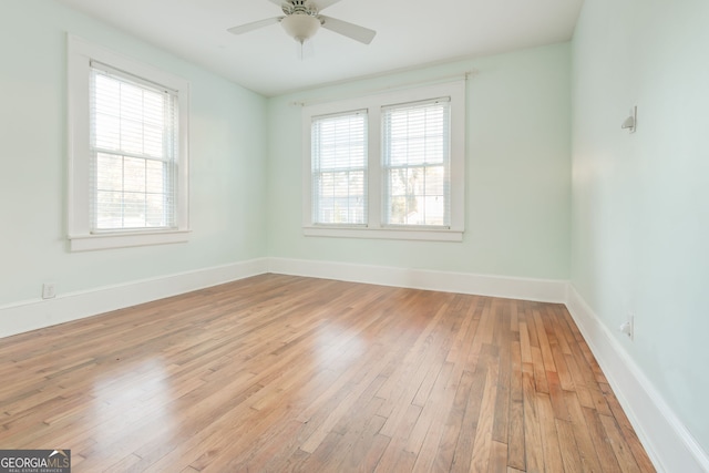 empty room featuring ceiling fan, plenty of natural light, and light hardwood / wood-style floors