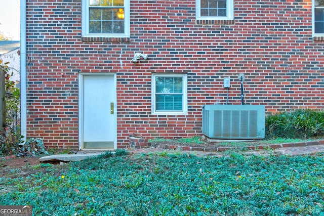 entrance to property with cooling unit and a yard