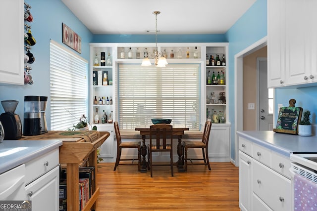 kitchen featuring open shelves, an inviting chandelier, white cabinets, and light wood finished floors