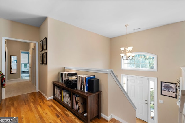 foyer featuring visible vents, baseboards, an inviting chandelier, and light wood-style flooring