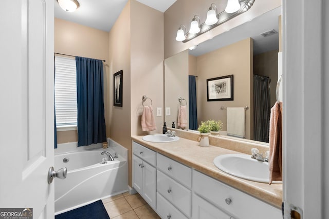 full bathroom with tile patterned flooring, double vanity, a bath, and a sink