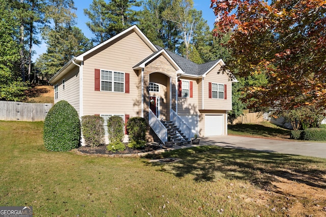 raised ranch featuring a garage and a front lawn