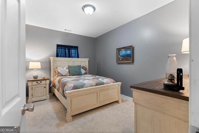 bedroom with light colored carpet and baseboards