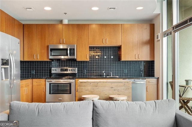 kitchen with stainless steel appliances and decorative backsplash