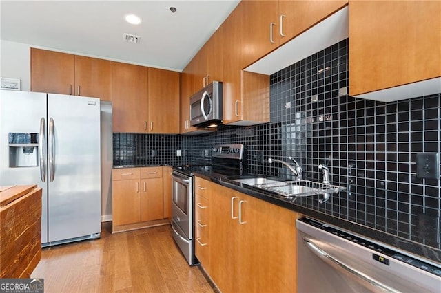 kitchen featuring tasteful backsplash, appliances with stainless steel finishes, sink, and dark stone counters