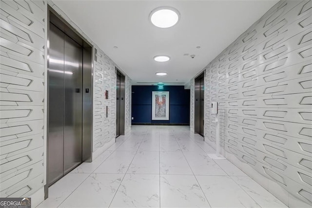 hallway with elevator and brick wall