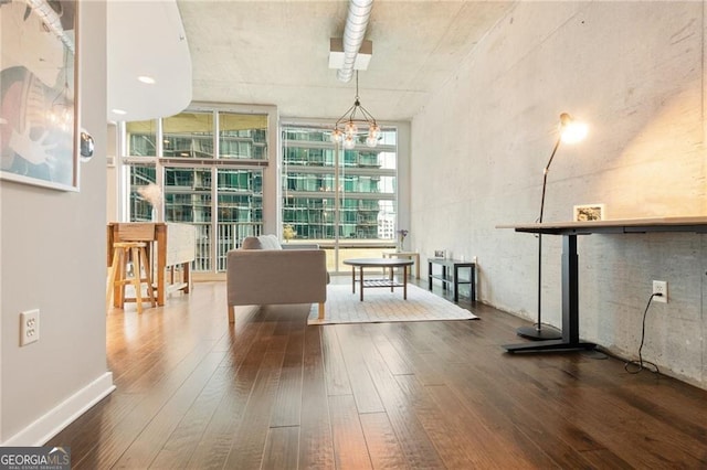 interior space featuring hardwood / wood-style flooring, floor to ceiling windows, and an inviting chandelier