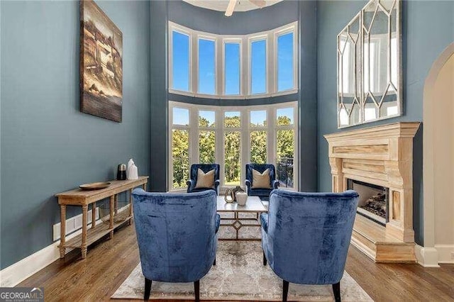 living area featuring a high ceiling, hardwood / wood-style flooring, a fireplace, and french doors