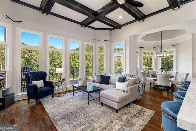 sunroom featuring coffered ceiling, ceiling fan with notable chandelier, and beamed ceiling