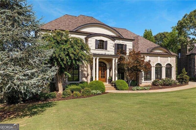 french provincial home with a front yard