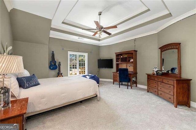 bedroom with crown molding, carpet, ceiling fan, and a tray ceiling