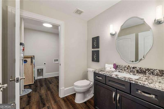 bathroom with vanity, toilet, and hardwood / wood-style flooring