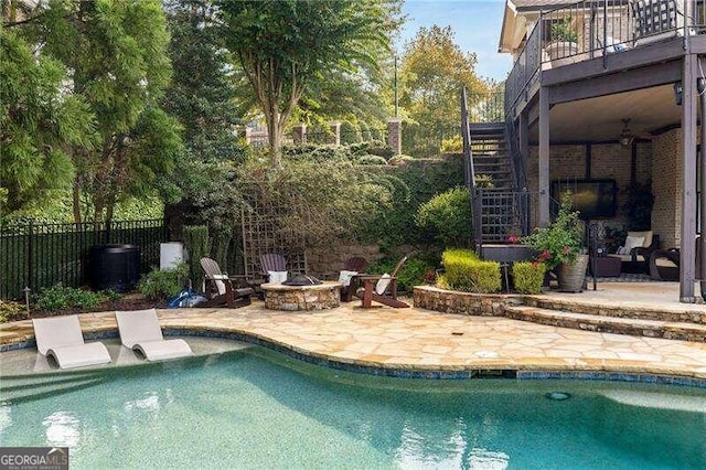 view of swimming pool with a patio area, a wooden deck, and an outdoor fire pit