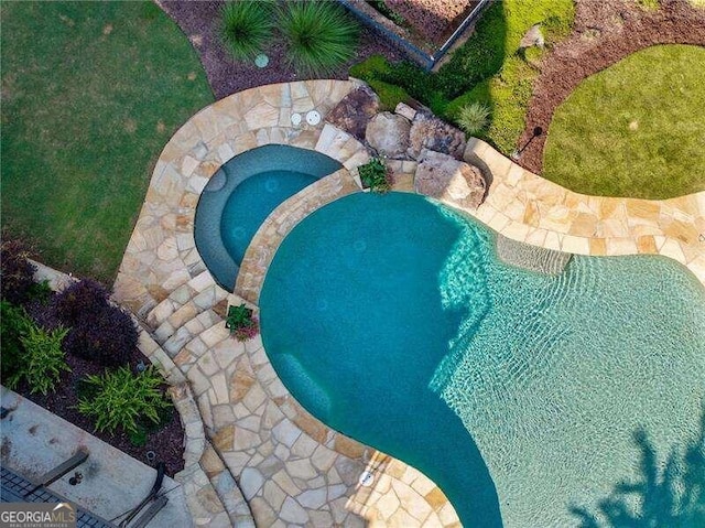 view of pool with an in ground hot tub