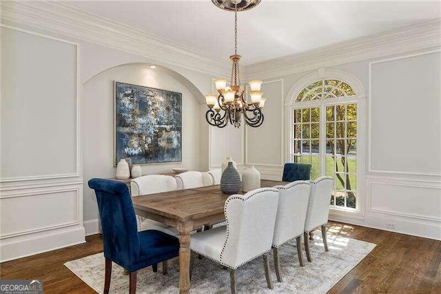 dining room with dark hardwood / wood-style floors, a chandelier, and crown molding