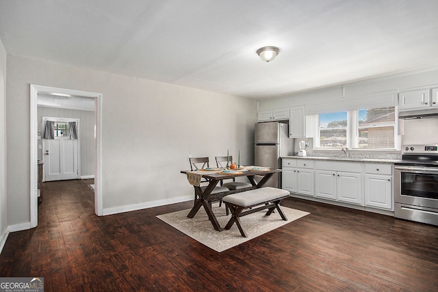 dining area featuring dark wood-type flooring and sink