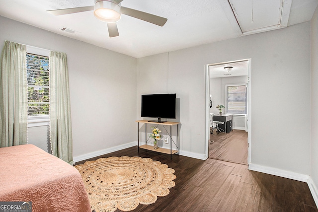 bedroom with ceiling fan, dark hardwood / wood-style floors, and multiple windows