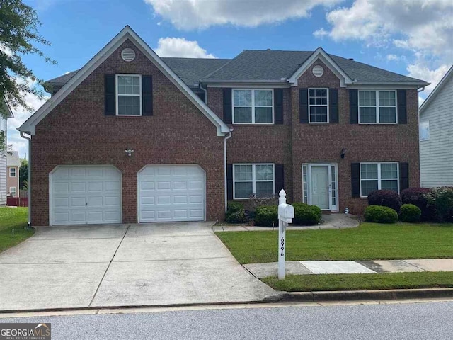 view of front of home with a garage and a front lawn