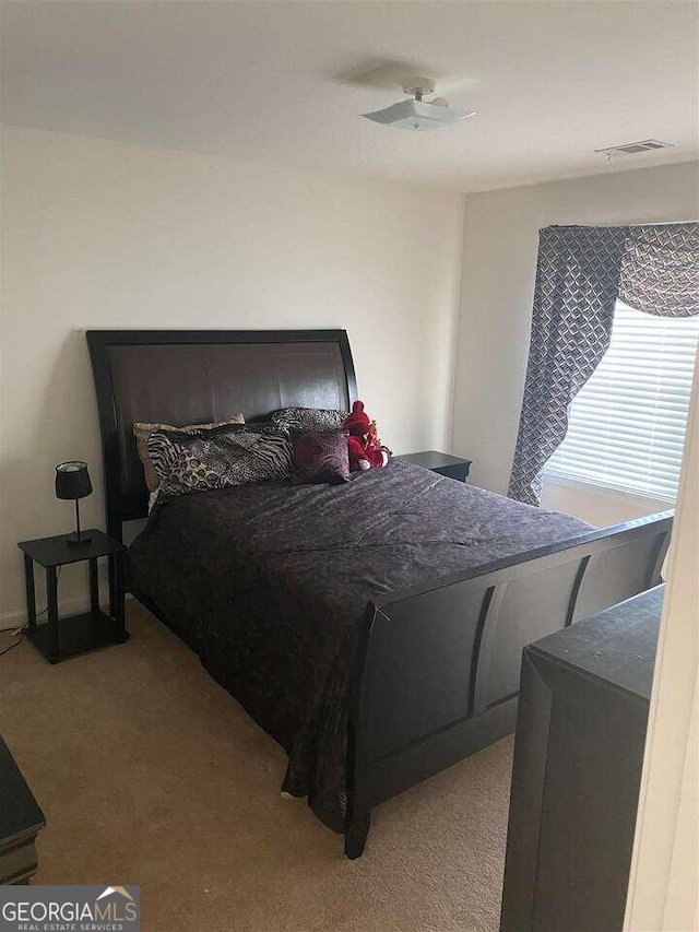 bedroom with ceiling fan and light carpet