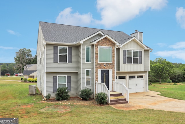 bi-level home featuring cooling unit, a garage, and a front yard