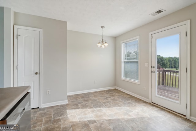 unfurnished dining area with stone finish floor, visible vents, baseboards, and an inviting chandelier