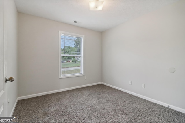 carpeted spare room with visible vents and baseboards