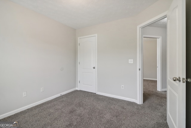 carpeted spare room featuring a textured ceiling