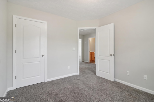 unfurnished bedroom with carpet flooring and baseboards