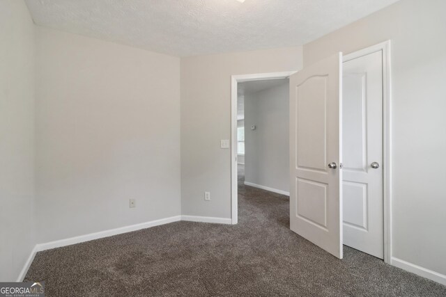 unfurnished bedroom featuring a textured ceiling and carpet flooring