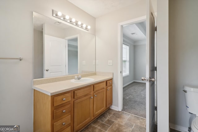 bathroom featuring visible vents, baseboards, vanity, and toilet