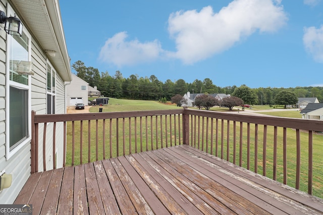 wooden deck featuring a lawn