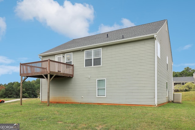 rear view of property with a shingled roof, a yard, and a wooden deck