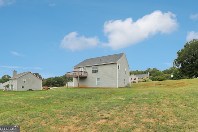 rear view of house with a yard and a wooden deck