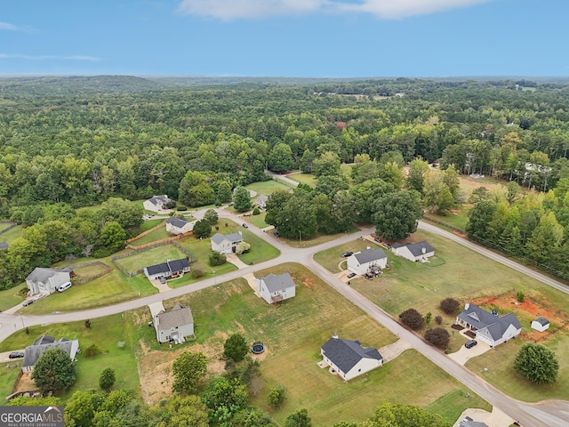 birds eye view of property featuring a view of trees