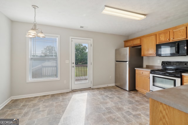 kitchen with pendant lighting, range with electric stovetop, stainless steel fridge, and a notable chandelier