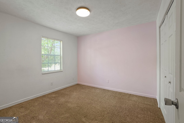 interior space featuring a textured ceiling, carpet flooring, and a closet