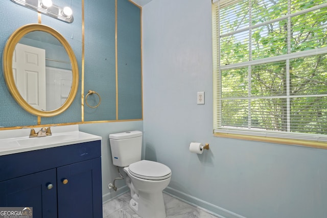 bathroom with a healthy amount of sunlight, toilet, and vanity