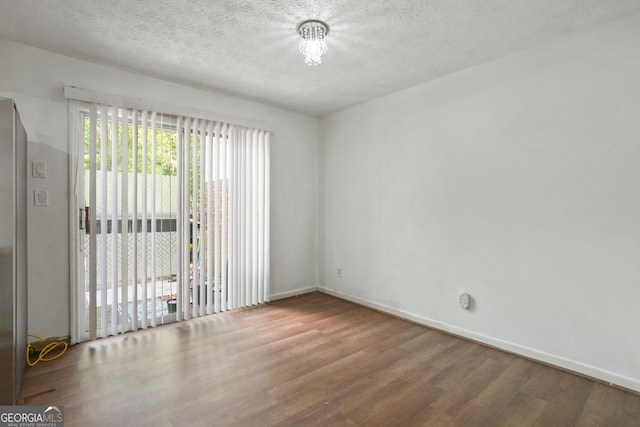 unfurnished room with a textured ceiling and hardwood / wood-style floors