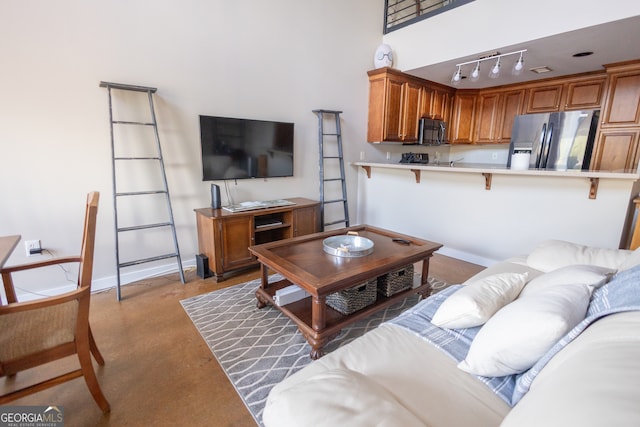 living room featuring track lighting and concrete floors