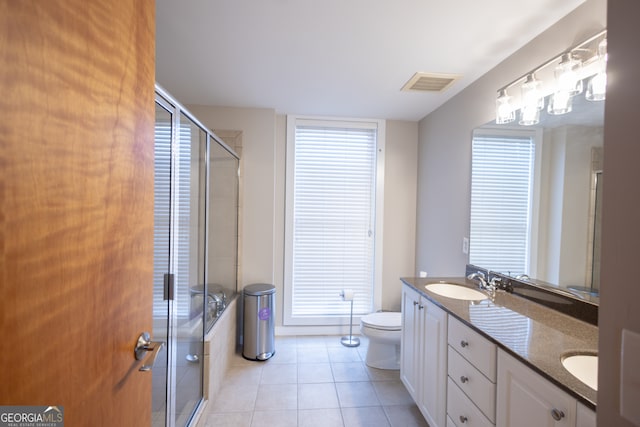 bathroom with vanity, toilet, an enclosed shower, and tile patterned floors