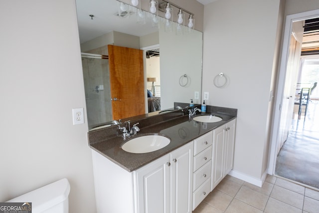 bathroom featuring tile patterned flooring, vanity, and walk in shower