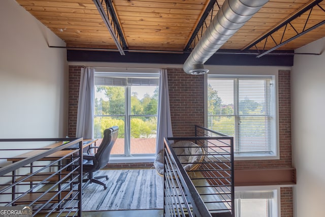 unfurnished office featuring wood ceiling, brick wall, and hardwood / wood-style floors