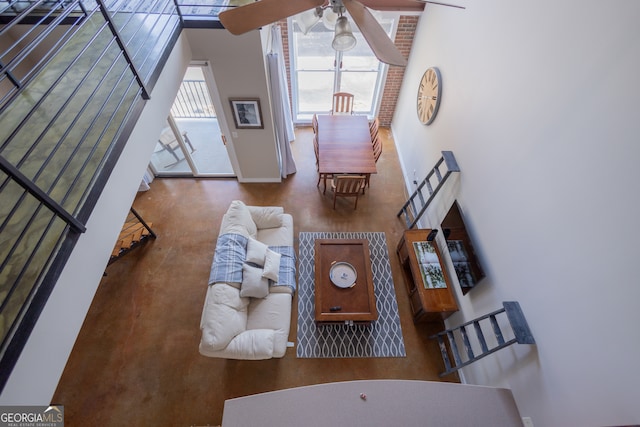 living room with a towering ceiling and ceiling fan