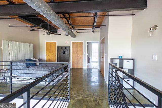 bedroom featuring a high ceiling and concrete flooring