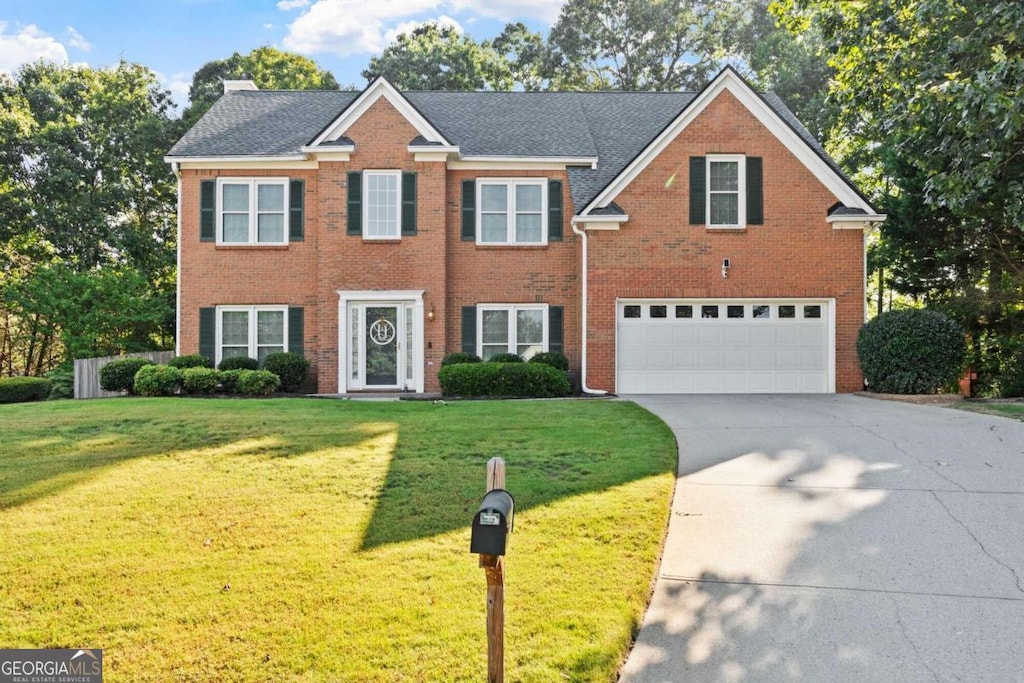 view of front of house featuring a garage and a front lawn