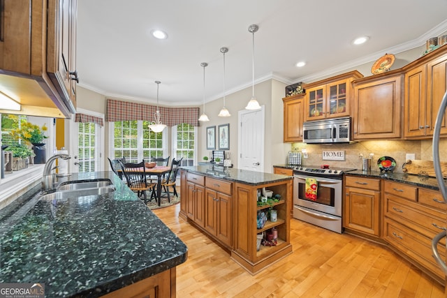 kitchen featuring appliances with stainless steel finishes, a kitchen island, sink, and light hardwood / wood-style floors