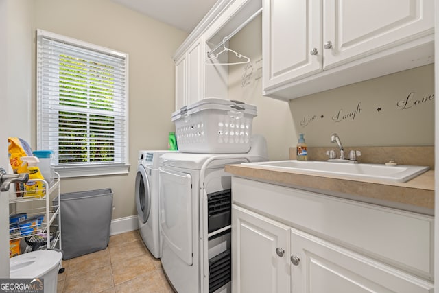 washroom featuring light tile patterned floors, cabinets, separate washer and dryer, and sink