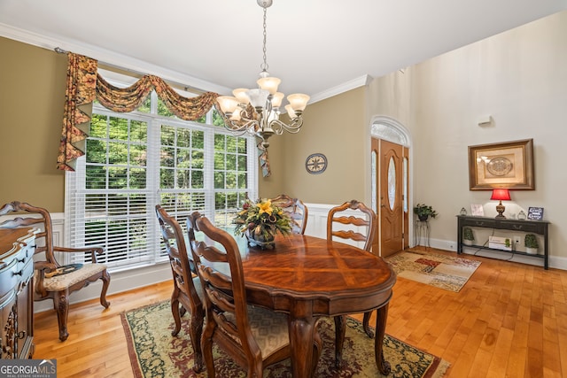 dining space with crown molding, a notable chandelier, and light hardwood / wood-style floors